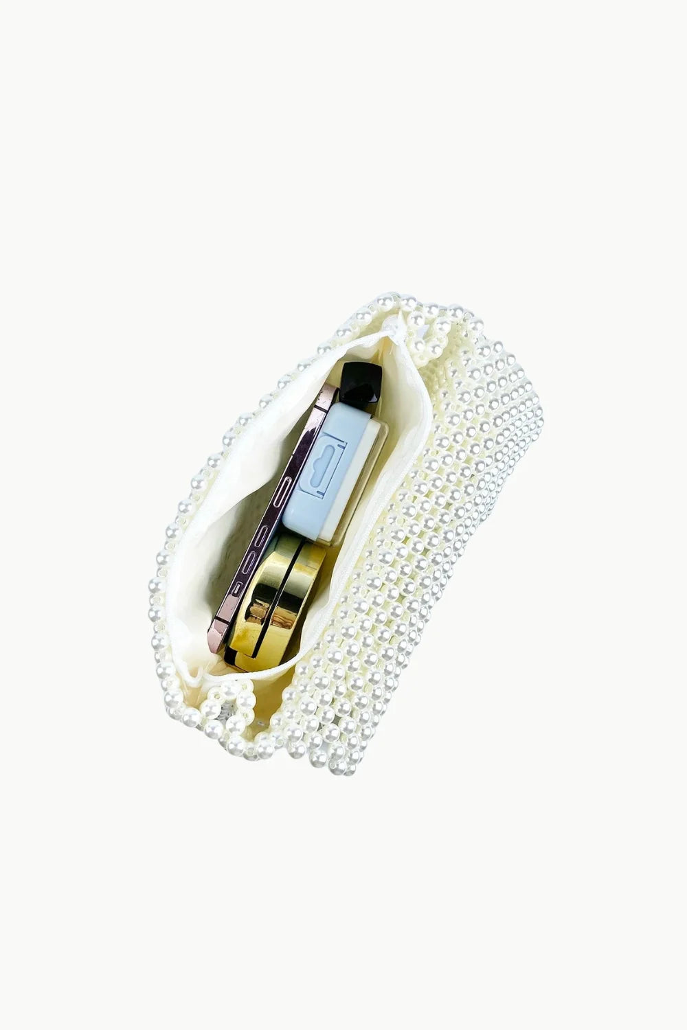 White pearl beaded bag with polyester main material holding light blue item and gold compact