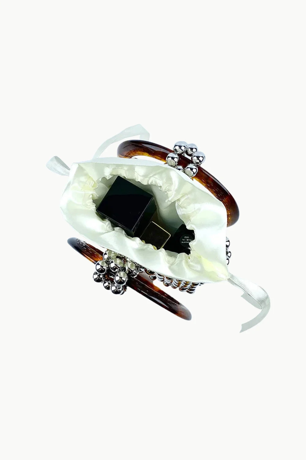 White satin pouch with dark bottles inside vintage beaded bucket bag for stylish storage