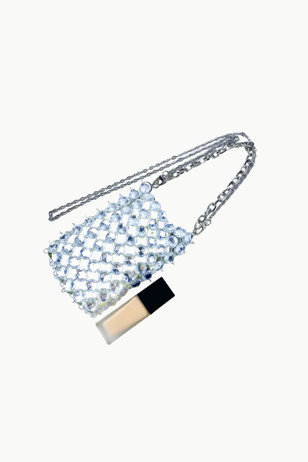 Beaded crystal bag with silver chain strap and liquid foundation for stylish beauty look