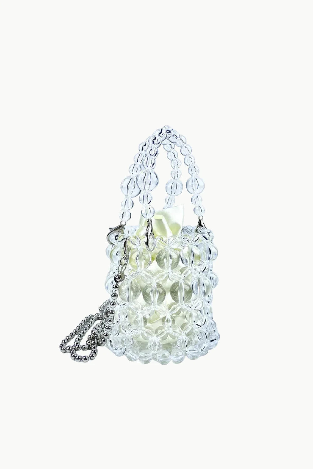Clear beaded bucket bag with silver chain strap and light-colored drawstring pouch for everyday style
