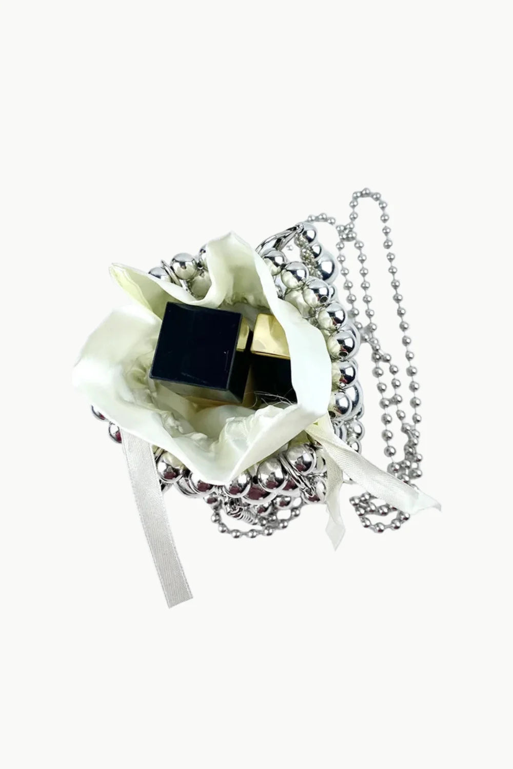 White gift bag with dark chocolates and silver beaded necklaces in a beaded bucket bag for everyday style