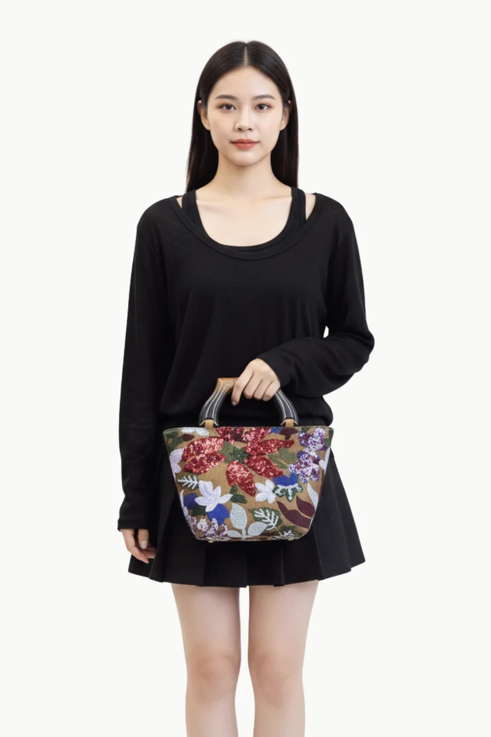 Black long-sleeved top and skirt with a floral flower hand bag for stylish fashion accessory