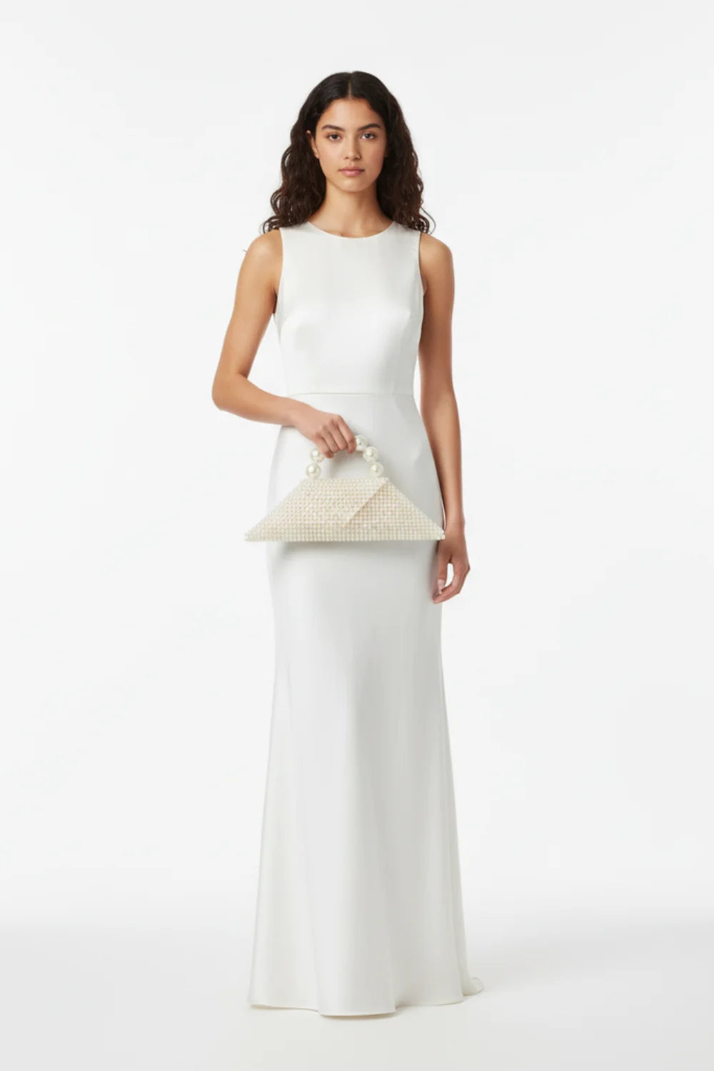 Woman in sleeveless white maxi dress holding a pearl designer bag and off-white clutch
