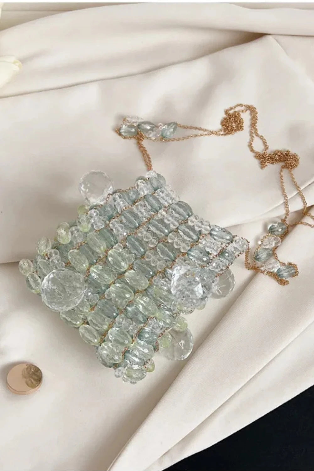 Light blue beaded handbag with gold chain strap, perfect for stylish orange beaded looks