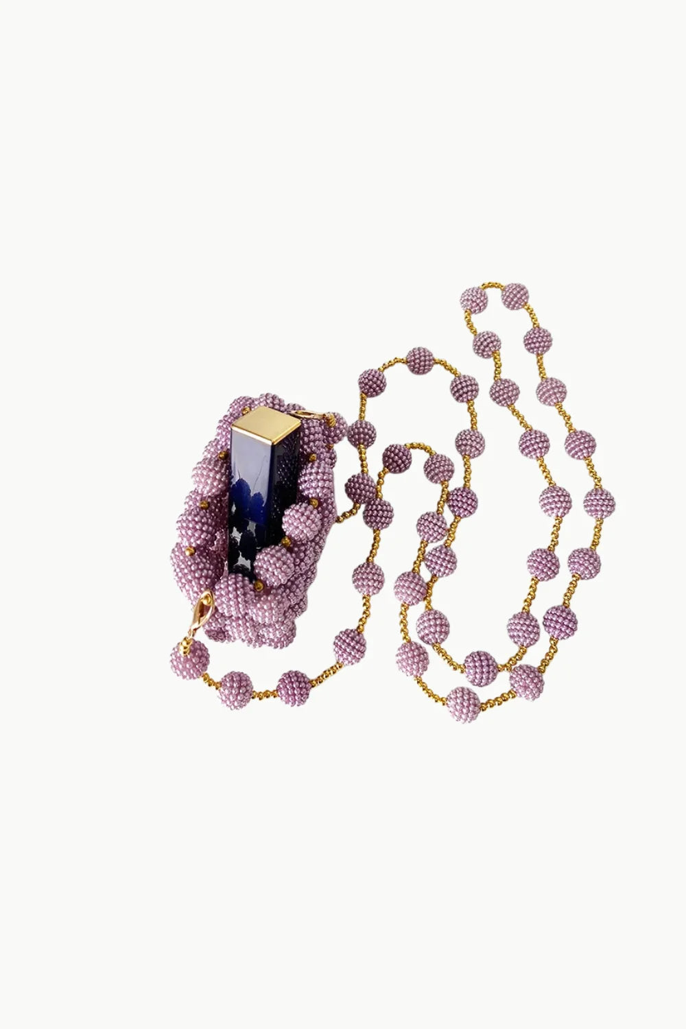 Pink beaded mini bag with gold chain necklace and matching beaded bracelet holding a dark blue rectangular object