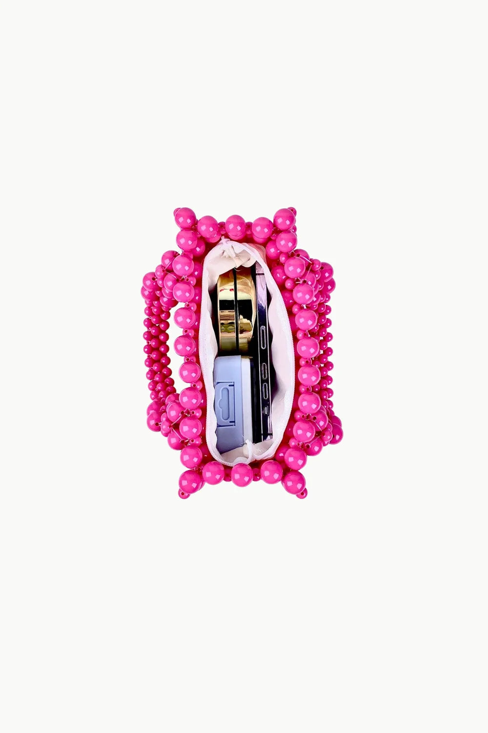 Vibrant pink beaded purse with white lining holding a gold compact and smartphone