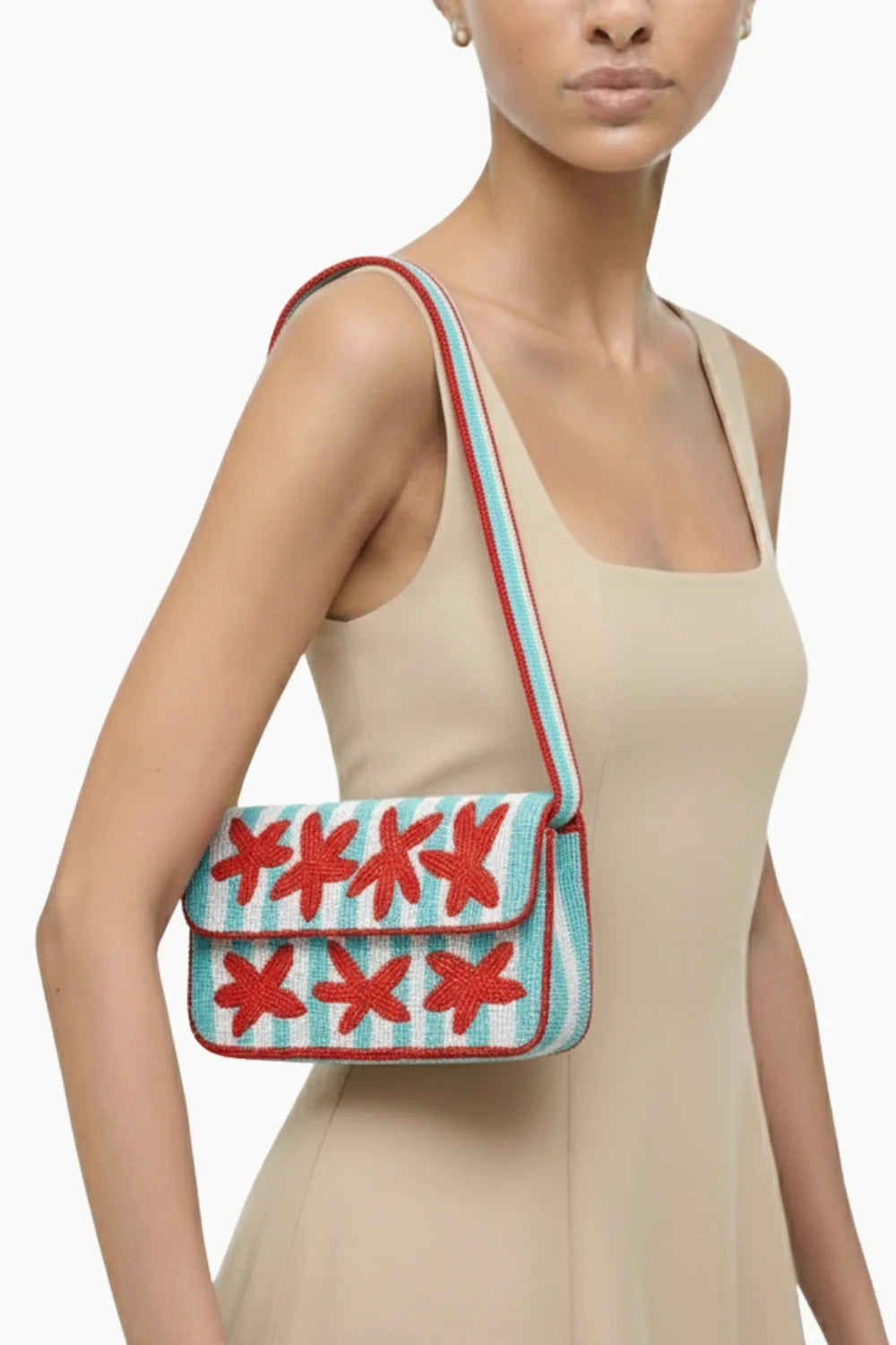 Beaded bag with seashell design and red starfish on light blue striped background