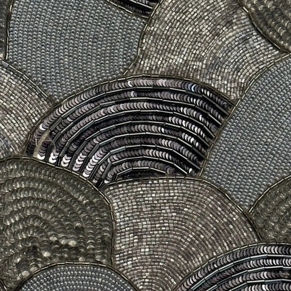 Detailed beadwork of silver and black beaded bag with overlapping scale pattern and sequins.