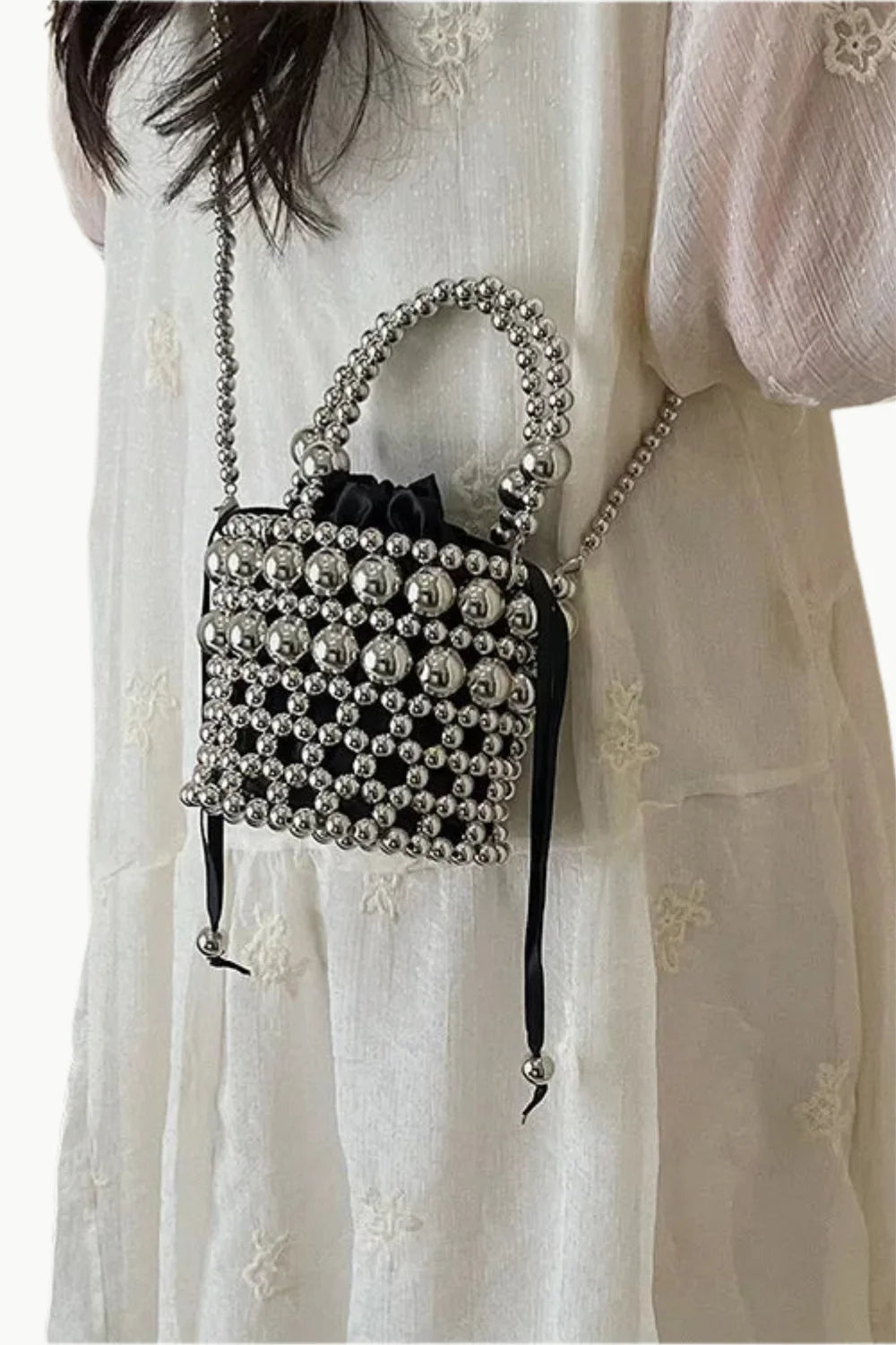 Silver bucket bag with beading, black drawstring pouch, and matching shoulder strap