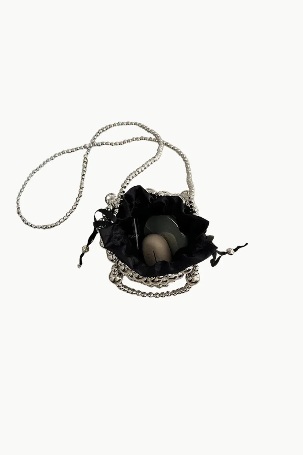 Silver bucket bag with beading featuring a black drawstring pouch, rhinestones, and unique objects