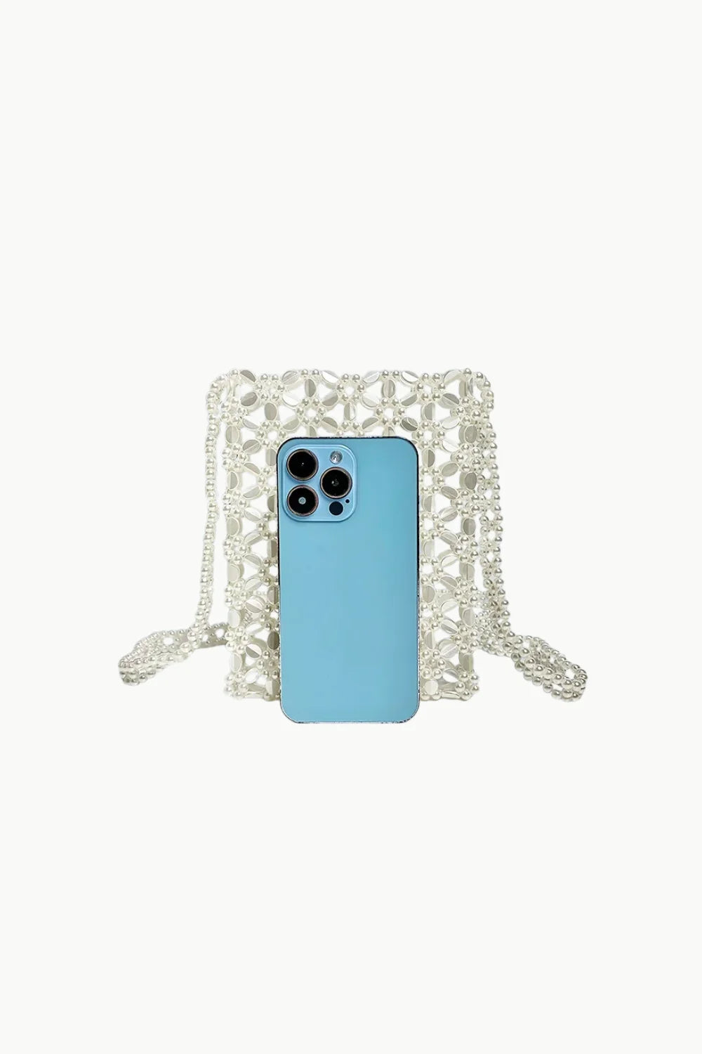 Light blue smartphone in front of white beaded crossbody handbag on white background