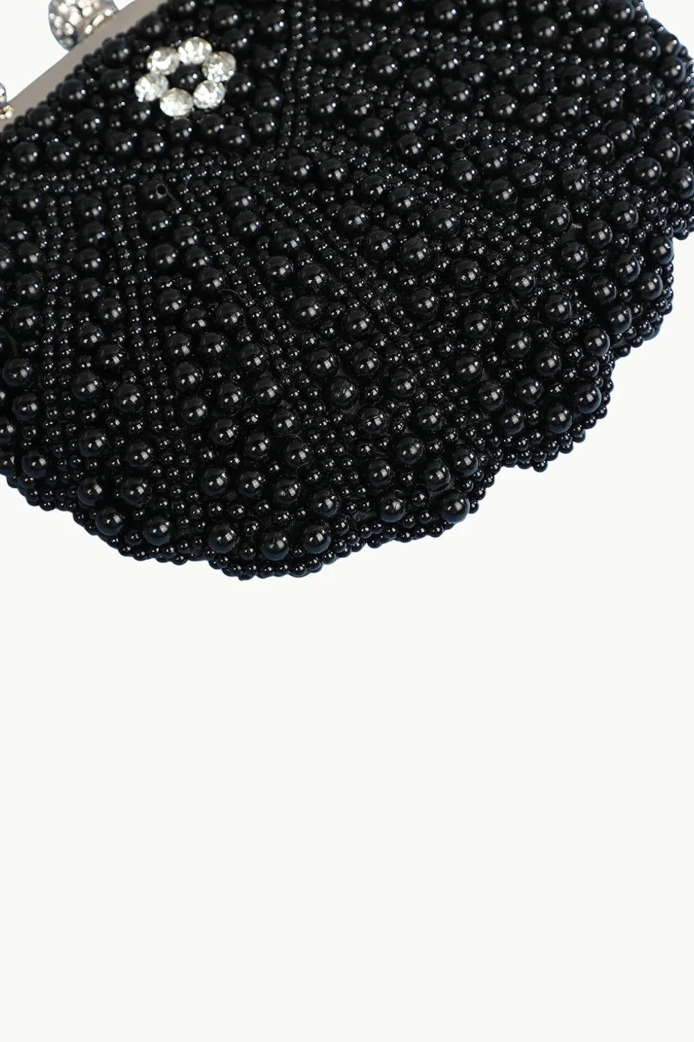 White pearl clutch bag with black beaded design and floral rhinestone clasp