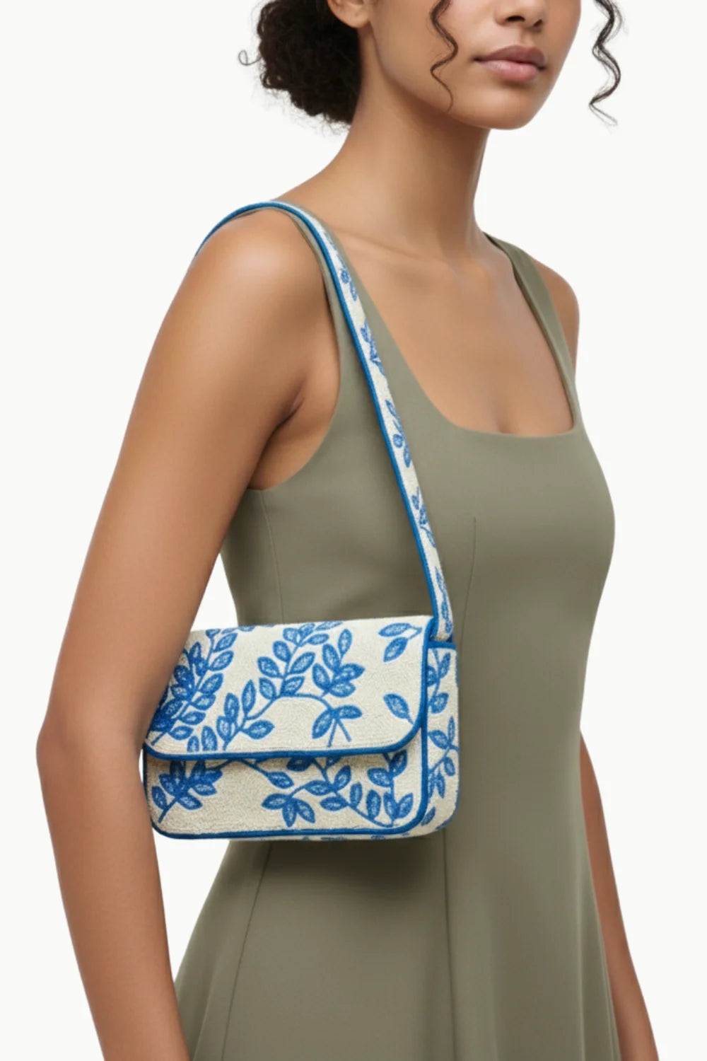 White shoulder bag with blue leaf embroidery and piping, a stylish beaded handbag for women