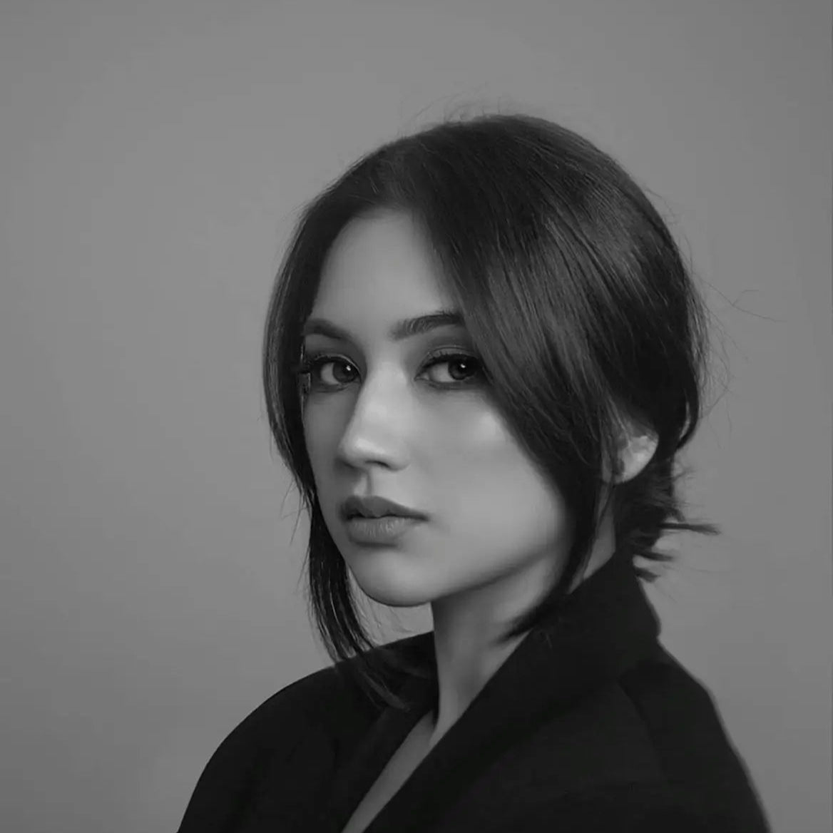 Modern woman in a tailored blazer, sleek studio portrait for Beaded Bag contemporary fashion aesthetic