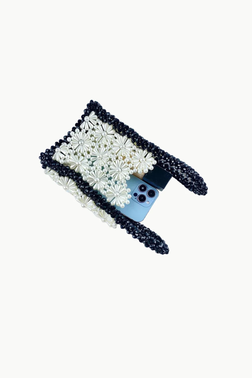 Black and white daisy-patterned beaded flower purse with light blue phone inside