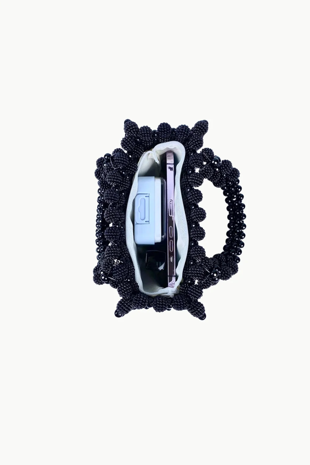 Black beaded evening handbag with light lining holding a blue object and smartphone