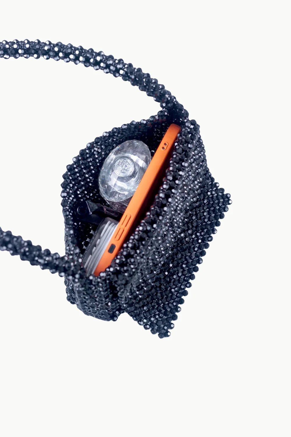 Black beaded evening purse with orange phone and perfume bottle inside