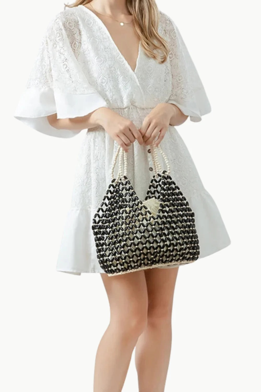 White eyelet wrap dress with a black wooden beaded tote bag for stylish summer look