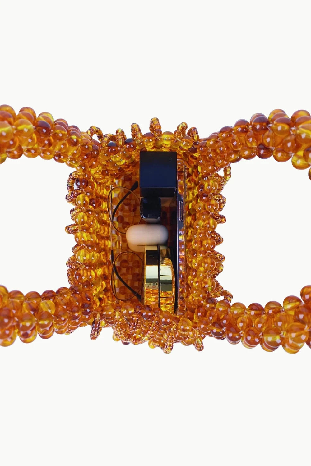 Amber-colored brown beaded bag with open top revealing small items inside