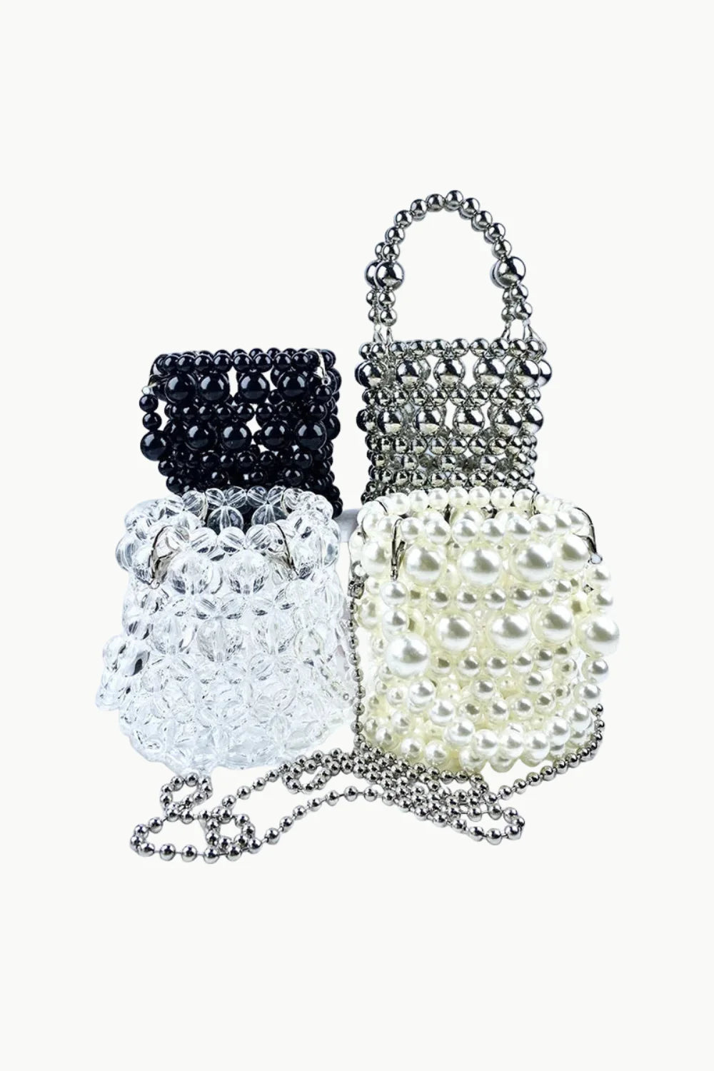 Four beaded bucket bags in black, silver, clear, and off-white with silver chain strap for everyday style