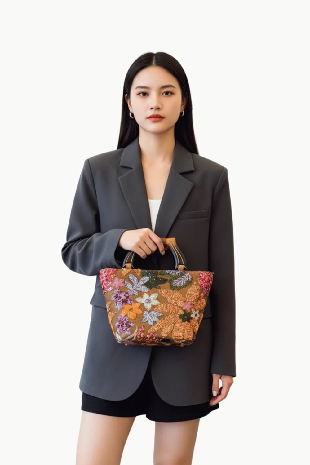 Dark gray oversized blazer with white top and black shorts holding a flower hand bag