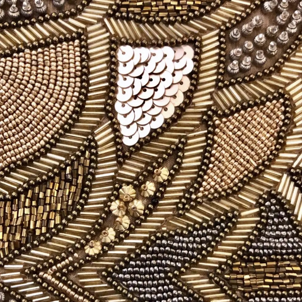 Close-up of gold beaded bag with sequins and floral bead pattern in geometric design.