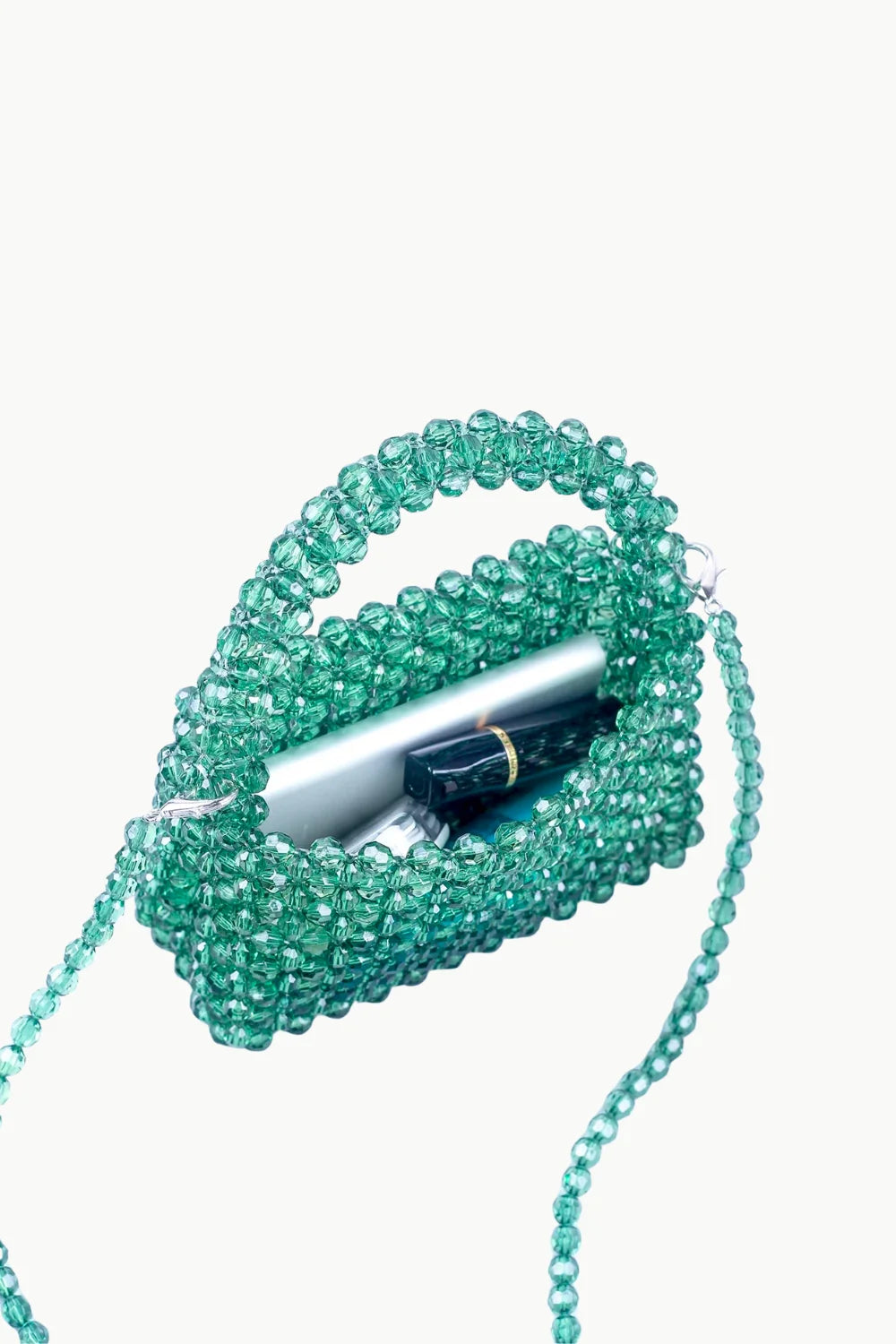 Green beaded evening clutch with shoulder strap and contents, stylish teal handbag