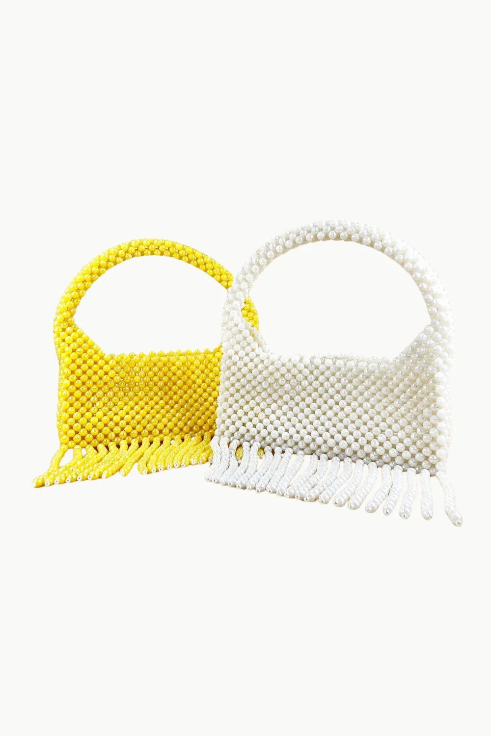 Two hand beaded purses with fringe, one yellow and one white, in a stylish beaded purse display