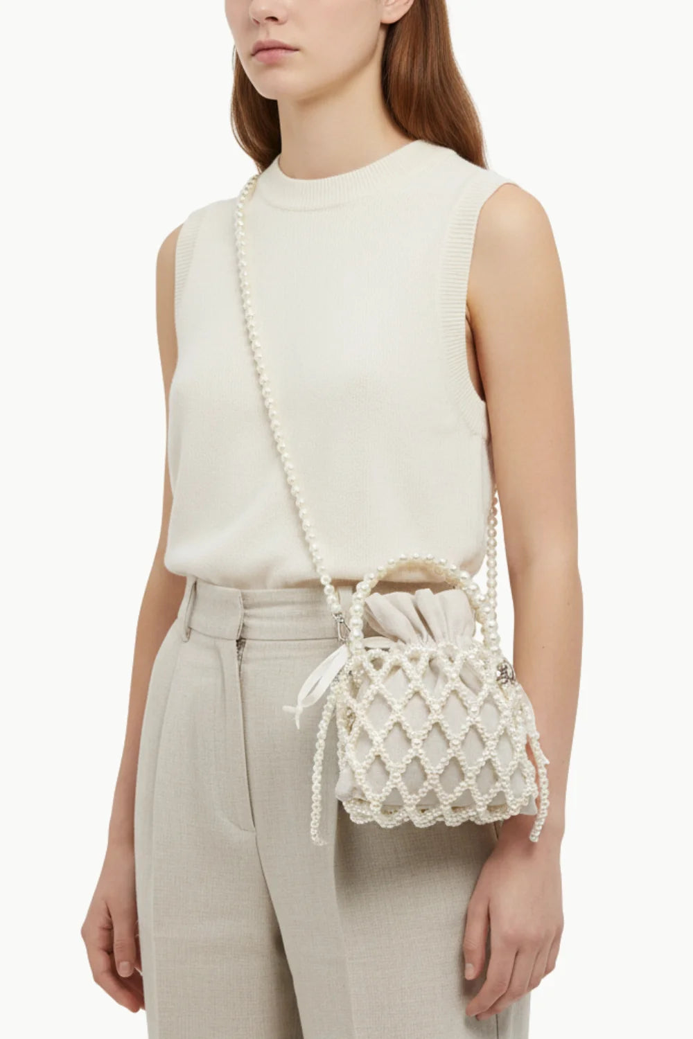 Cream sleeveless top and light beige trousers paired with Pearl Beaded Bucket Bag