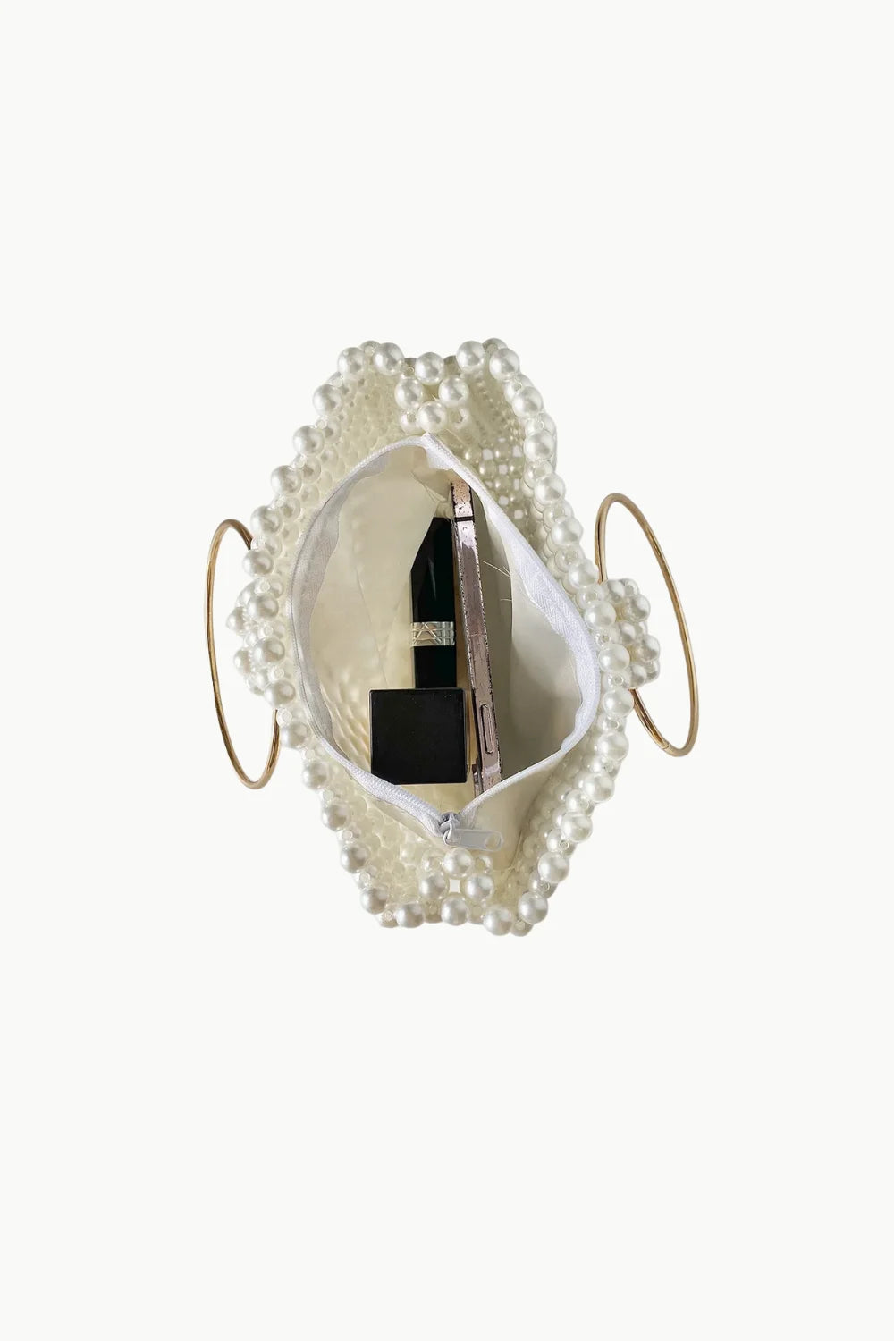 White Pearl Cage Bag with gold ring handles holding lipstick and small accessories