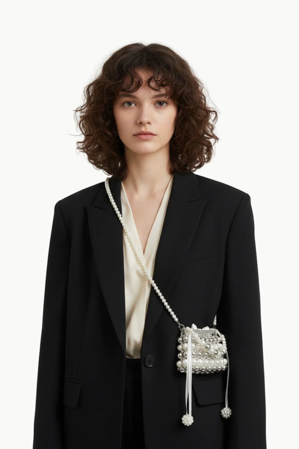 Elegant woman with black blazer carrying a pearl clutch bag for wedding occasions