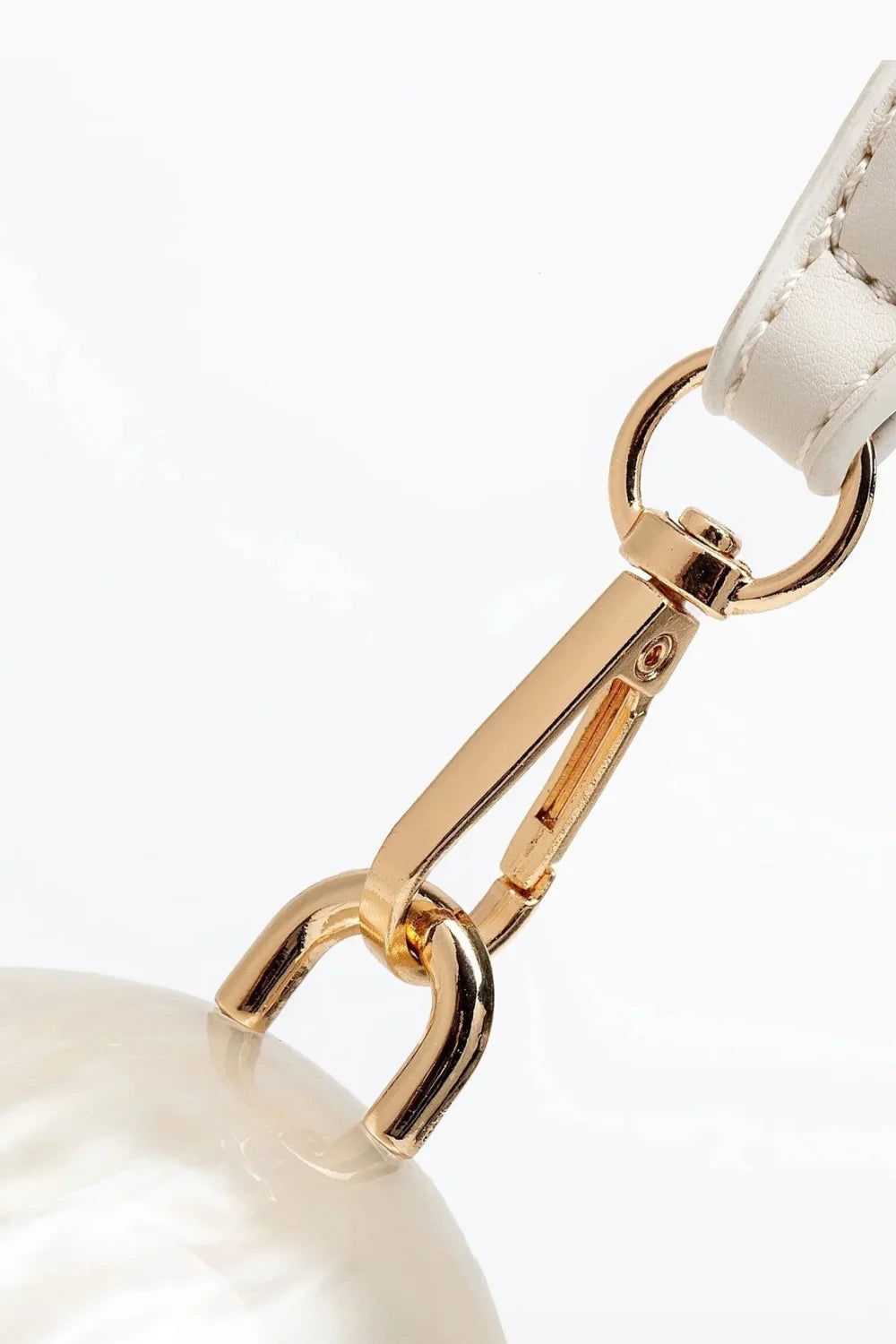 Gold metal clasp with white leather strap on Pearl Mini Bag plush ball accessory