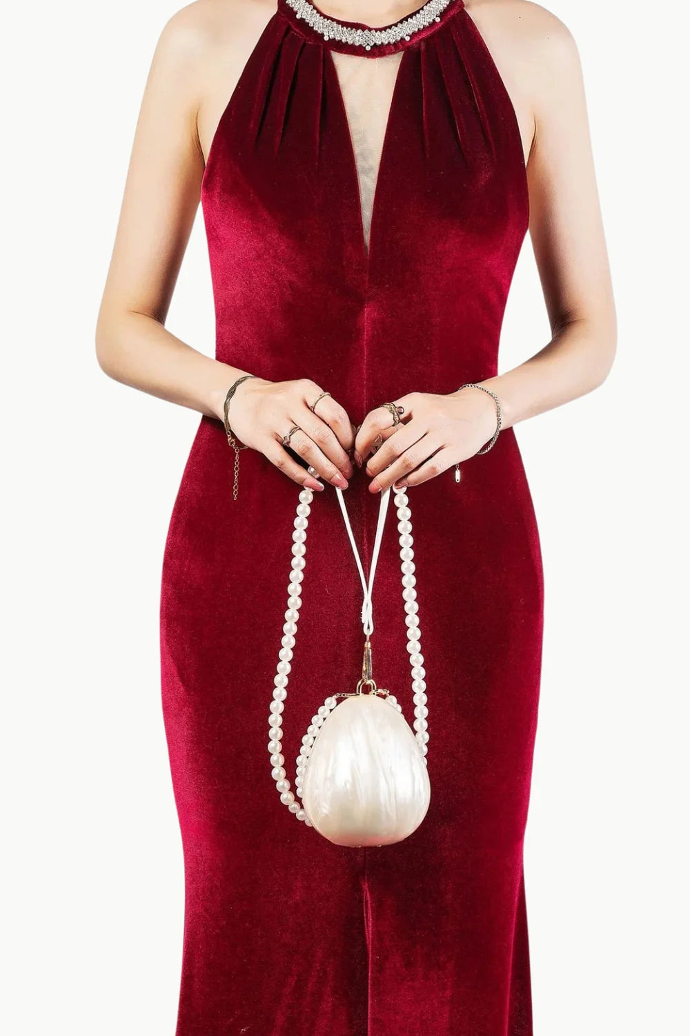 Red velvet halter-neck evening gown with pearl mini bag and clutch accessory