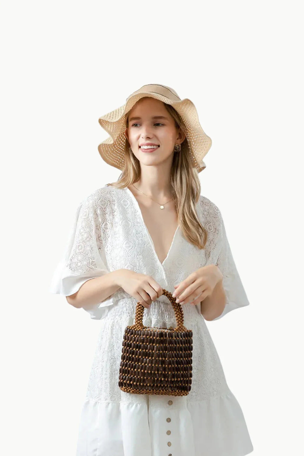 White lace dress with V-neck and bell sleeves paired with Rattan Beaded Bucket Bag