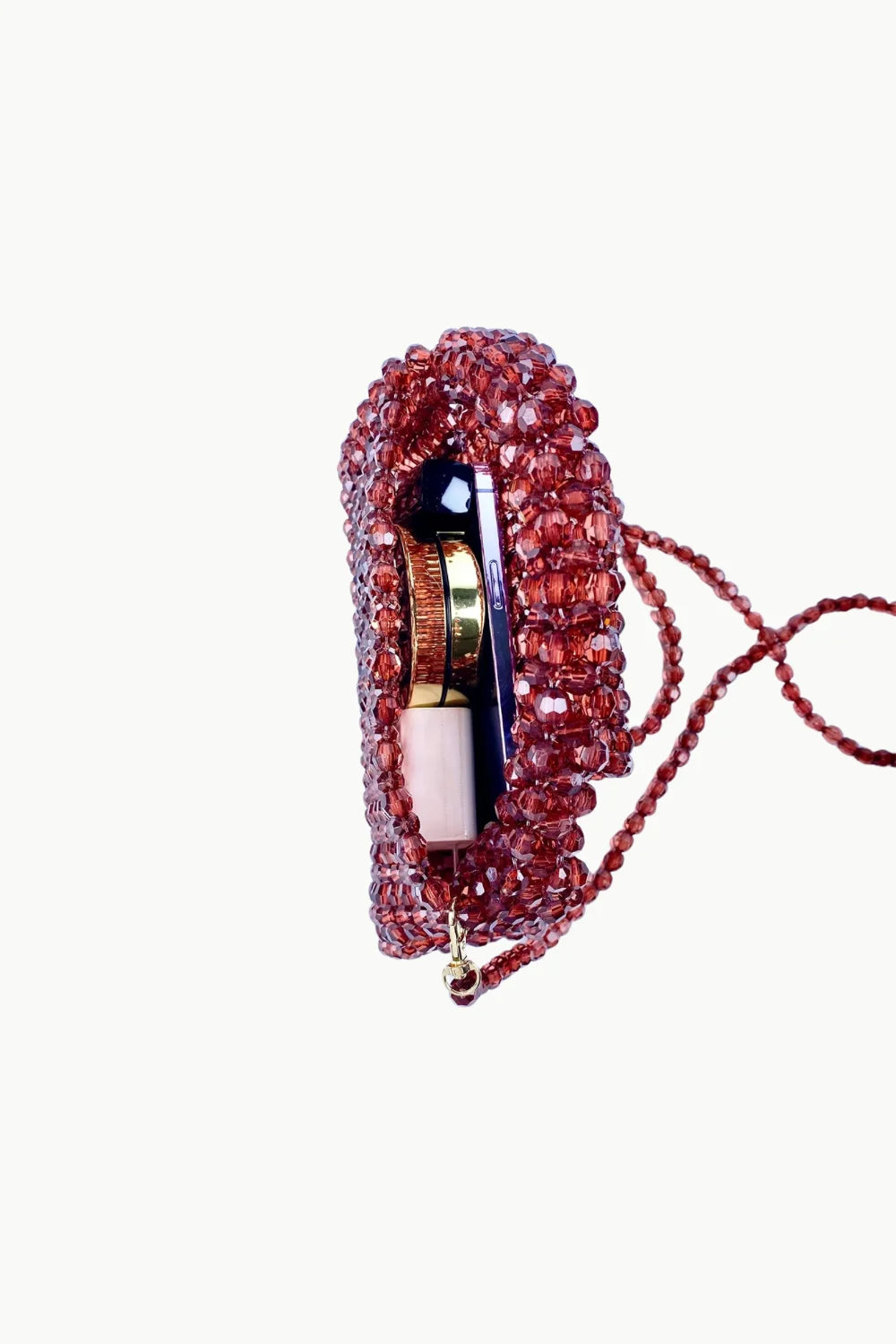 Red beaded evening bag with shoulder strap, lipstick, and compact mirror inside