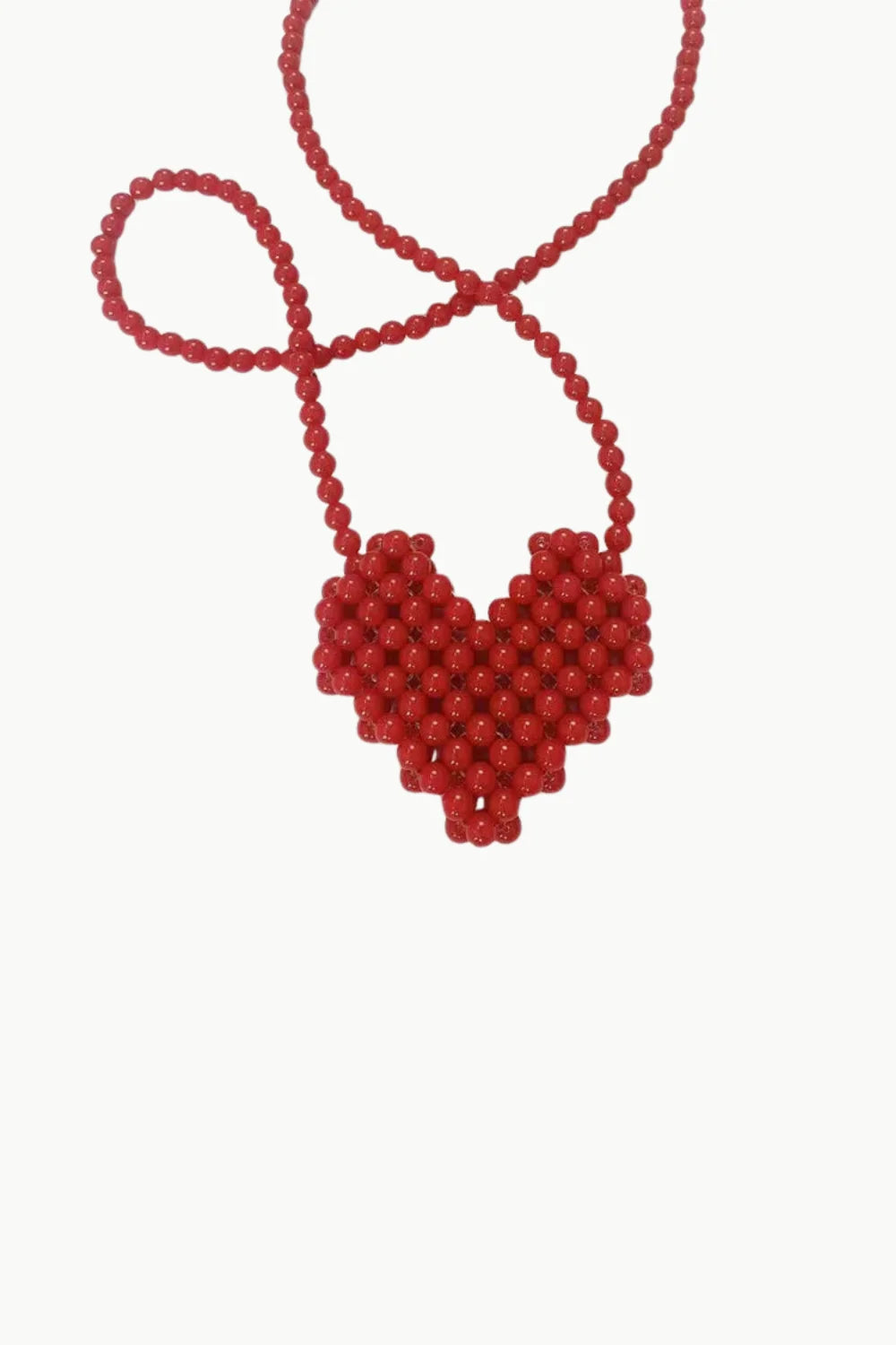 Red beaded heart-shaped necklace displayed on Red Mini Beaded Bag for stylish accessories