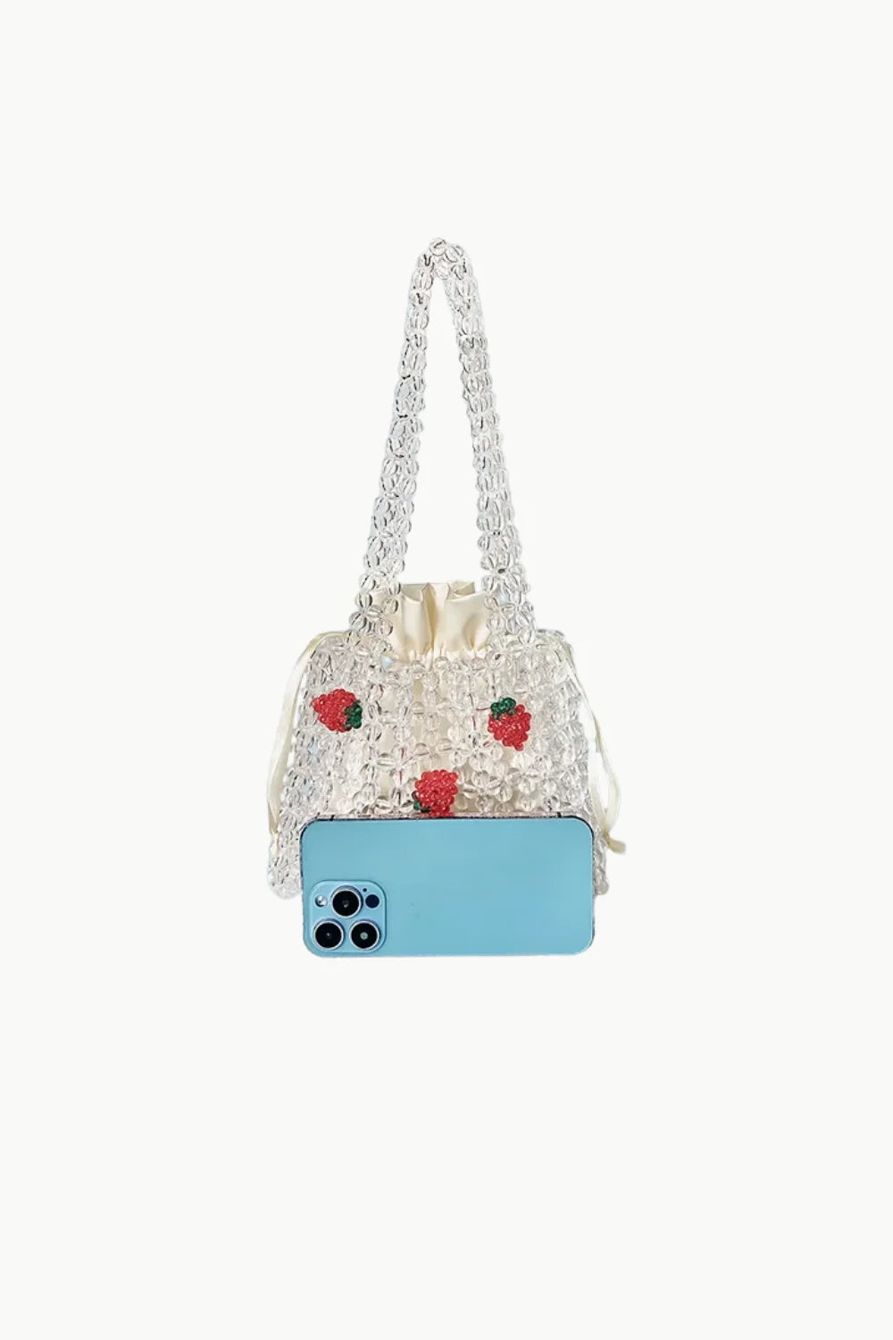 White beaded shoulder bag with red strawberry appliques and light blue smartphone