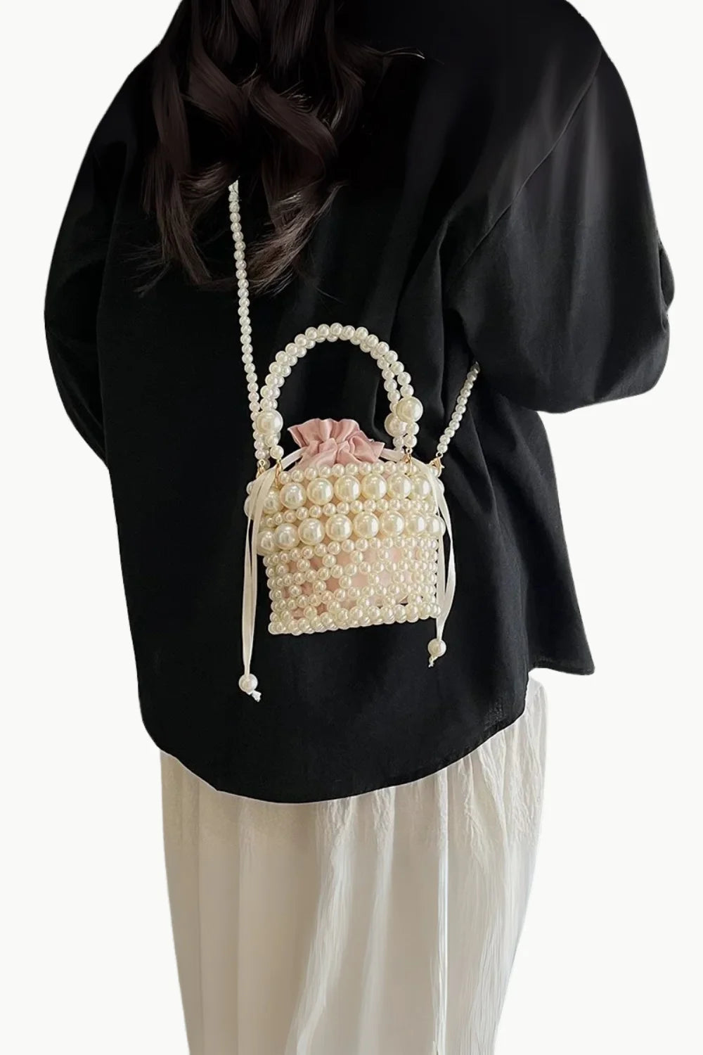 Pearl-beaded bucket bag with pink drawstring lining and pearl top handle for trendy bead bucket style