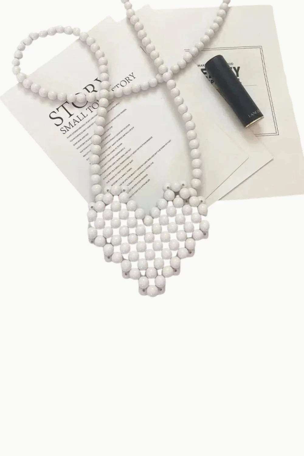 White beaded heart-shaped necklace on White Mini Beaded Bag, stylish beaded bag accessory
