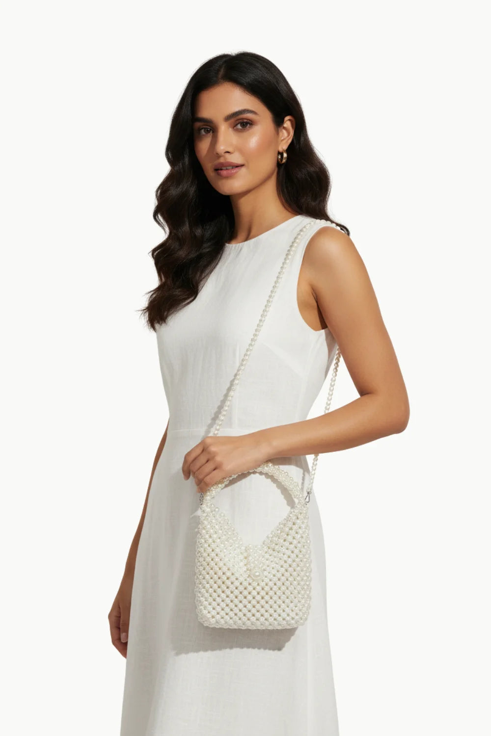 White pearl bag with a sleeveless dress, perfect for elegant occasions