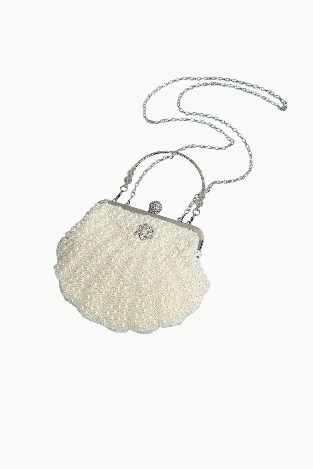 Cream-colored shell-shaped white pearl clutch bag with pearls, silver chain strap, and rhinestone clasp