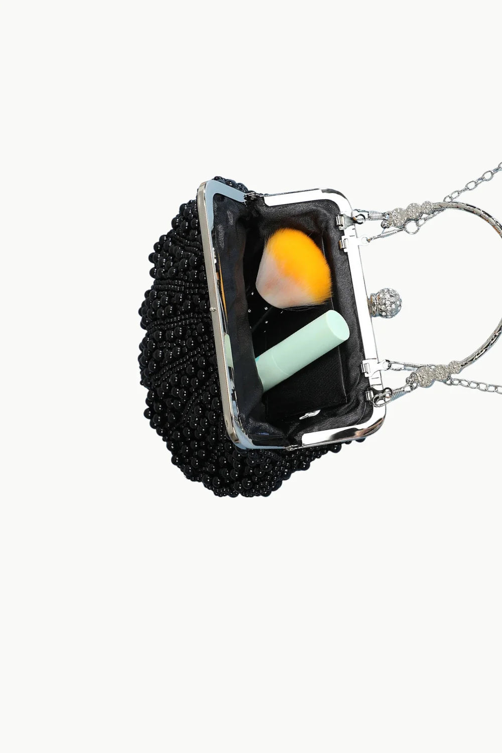 White Pearl Clutch Bag with black beads, silver frame, chain handle, beauty blender, and lip balm