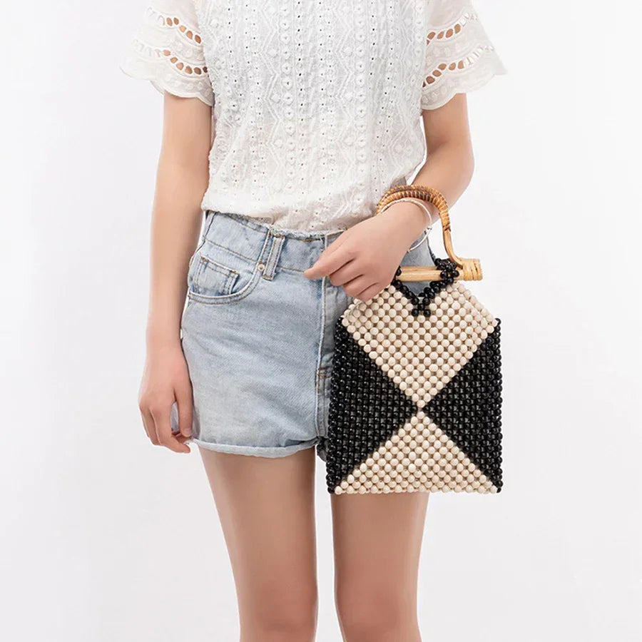 Woman holding a stylish wood bead purse with wooden handle and black and white beads