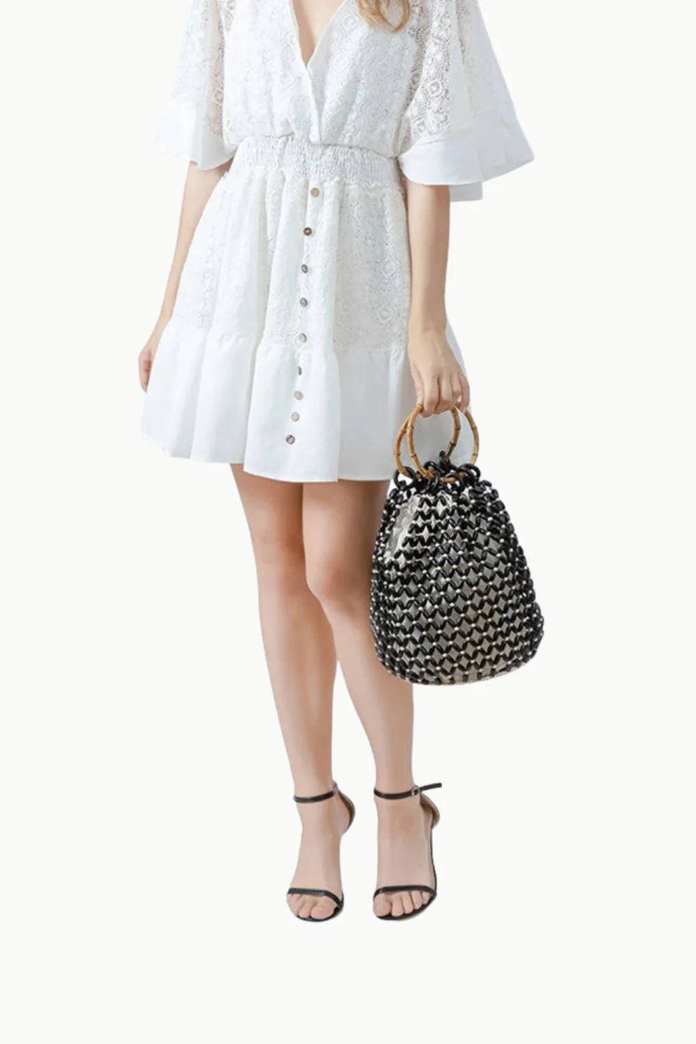 Woman in white dress holding a stylish wooden bead bucket bag with black beads